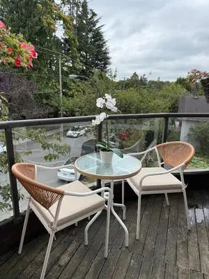 a patio with a table and chairs on a balcony at Boutique Beach Apartment in Vancouver