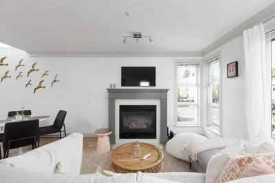 a living room with a couch and a fireplace at Boutique Beach Apartment in Vancouver