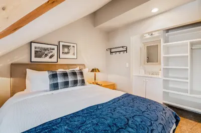 a bedroom with a large bed with a blue blanket at The Crest, Spacious, Central Condo, Free Parking in Whistler