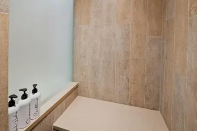 a shower with a bench in a bathroom at The Nest, Central, Luxury Unit, Free Parking in Whistler