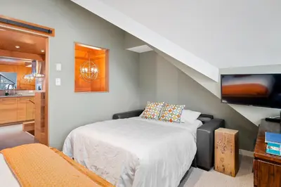 a small bedroom with a bed and a tv at The Nest, Central, Luxury Unit, Free Parking in Whistler