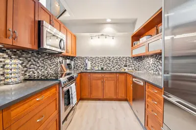 a kitchen with wooden cabinets and stainless steel appliances at The Nest, Central, Luxury Unit, Free Parking in Whistler