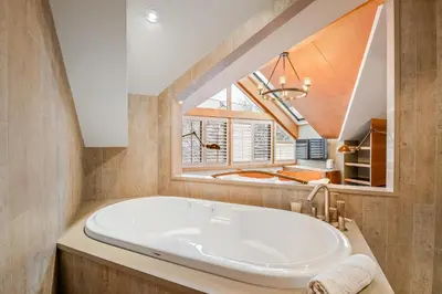 a large white tub in a bathroom with a window at The Den, Heart of Village, Free Parking in Whistler