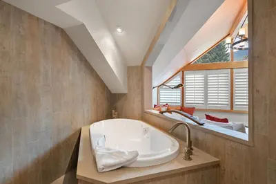 a bathroom with a large tub and a window at The Den, Heart of Village, Free Parking in Whistler