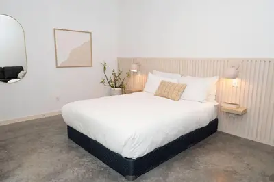 a bedroom with a large bed with white sheets at White Haus 2 - Rainforest heaven close to beaches in Ucluelet