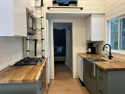 a kitchen with a sink and a stove top oven at Malaspina Strait Tiny Home in Powell River