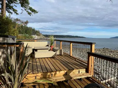 a wooden deck with a view of the water at Malaspina Strait Tiny Home in Powell River