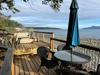 a patio with a table and an umbrella at Malaspina Strait Tiny Home in Powell River