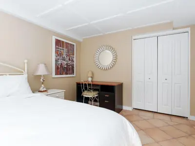 a bedroom with a bed and a desk and a mirror at Ferry Walk House in West Vancouver