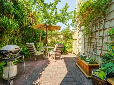 a patio with a table and chairs and an umbrella at Ferry Walk House in West Vancouver