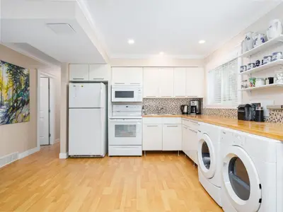 a kitchen with a refrigerator and a washer and dryer at Ferry Walk House in West Vancouver