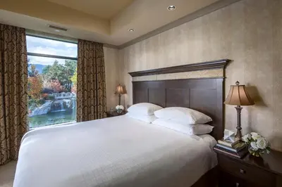 a bedroom with a large bed with a large window at The Royal Kelowna - Bellstar Hotels & Resorts in Kelowna