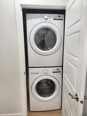 a washer and dryer in a small room at Brand New Deluxe 2 Bedroom Suite with AC & Den in Calgary
