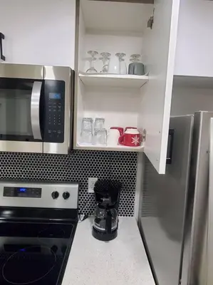 a kitchen with a stove and a microwave at Charming 2-Bedroom Basement Oasis Sleeps 5,Size-150sqm, Netflix, family friendly in Edmonton