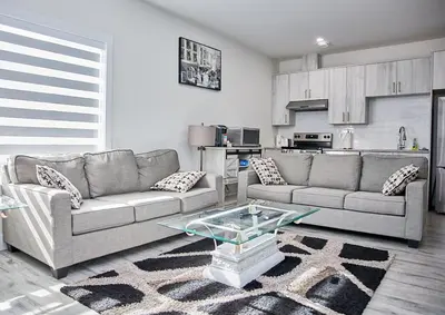 a living room with a couch and a table in it at Brand-new three bedroom guest suite in the desirable neighbourhood in Prince George
