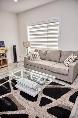 a living room with a couch and a glass table at Brand-new three bedroom guest suite in the desirable neighbourhood in Prince George