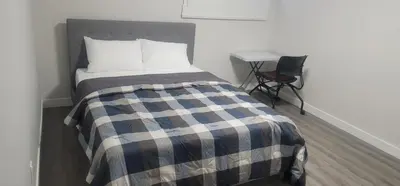 a bedroom with a bed and a chair and a desk at A Cozy home away from home at South East Calgary in Calgary