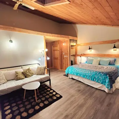 a bedroom with a bed and a couch at Hummingbird B&B in Gabriola