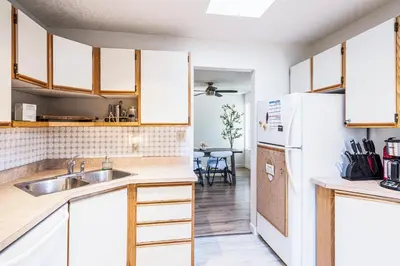 a kitchen with a sink and a refrigerator at Entire home minutes from 3 lakes and a river! in Nanaimo