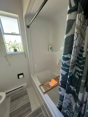 a bathroom with a bath tub with a shower curtain at Entire home minutes from 3 lakes and a river! in Nanaimo