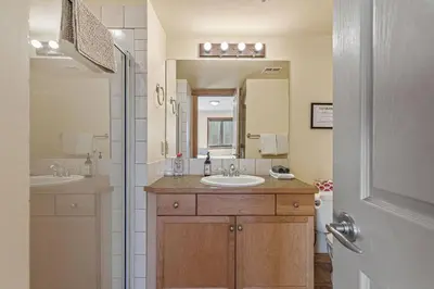 a bathroom with two sinks and a large mirror at C303 Hidden Gem with MTN andCreek View, Quiet and Private in Canmore