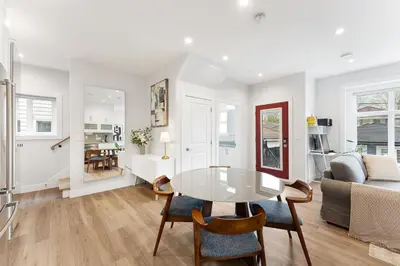 a white living room with a table and a couch at Charming 3BR Home in a Lovely Vancouver Neighborhood in Vancouver