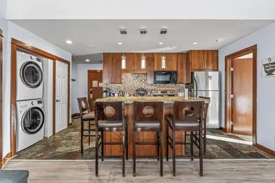 a kitchen with a counter and a stove top oven at S105 Canmore Stay- Hot tub, stream rm, gym, parking Mtn Retreat in Canmore