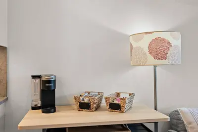 a coffee maker on a table next to a lamp at The Beach House at Saratoga Oceanfront Escape in Oyster Bay