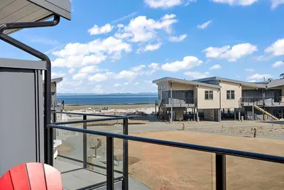 a balcony with a view of the beach and buildings at The Beach House at Saratoga Oceanfront Escape in Oyster Bay