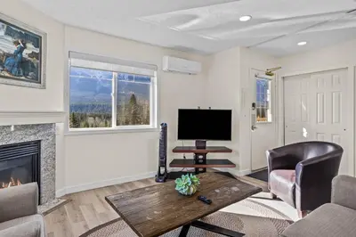 a living room with a fireplace and a tv at B212 Hot Tub, AC x3, parking, 2 min to Banff Gate in Canmore