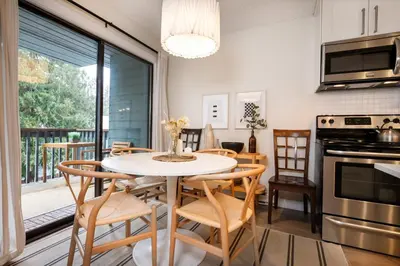 a kitchen with a table and chairs and a balcony at Creekside Oasis 4 Beds Pool and Hot Tub in Whistler