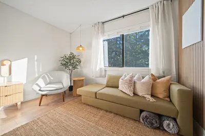 a living room with a couch and a chair and a window at Cozy Creek Den - Updated Nov 2025 in Whistler
