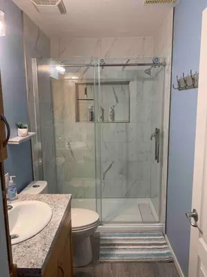 a bathroom with a shower with a toilet and a sink at Cozy Lodge Suite in Sylvan Lake