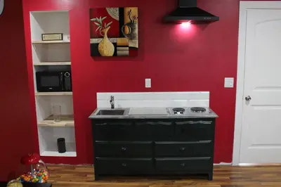 a kitchen with a sink and a red wall at Cozy Lodge Suite in Sylvan Lake