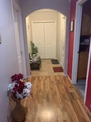 a hallway with a vase of flowers on the floor at Cozy Lodge Suite in Sylvan Lake