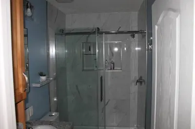 a shower with a glass door in a bathroom at Cozy Lodge Suite in Sylvan Lake