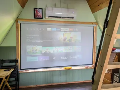 a large screen in a room with a presentation at Farmhouse cabin on 33 acre farm in Powell River