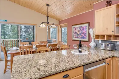 a kitchen and dining room with a table and chairs at Best Ski-in out 3 Bdrm Chalet, with Hot Tub in Big White