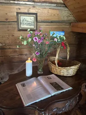 a table with a book and a candle and flowers at Rustic Beaverfoot Lodge Room N3 in Parson