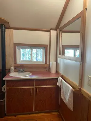 a bathroom with a sink and a mirror at Rustic Beaverfoot Lodge Room N3 in Parson