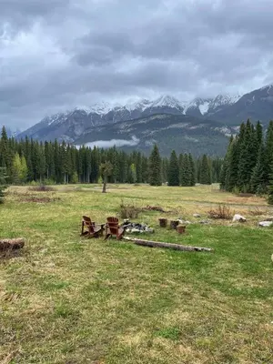 a field with benches and mountains in the background at Rustic Beaverfoot Lodge Room N4 in Parson