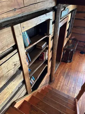 a book shelf with books inside of a wooden building at Rustic Beaverfoot Lodge Room N6 in Parson