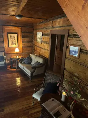 a living room of a log cabin with a couch at Rustic Beaverfoot Lodge Room N6 in Parson