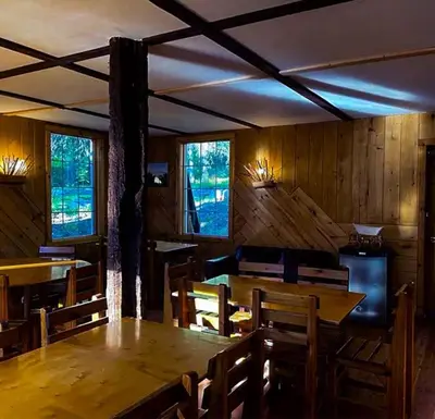 a dining room with a table and chairs and windows at Rustic Beaverfoot Lodge Room N6 in Parson