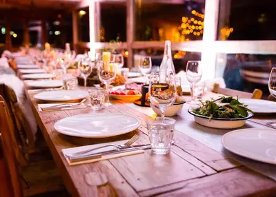 a long wooden table with plates and glasses of wine at Rustic Beaverfoot Lodge Room N6 in Parson