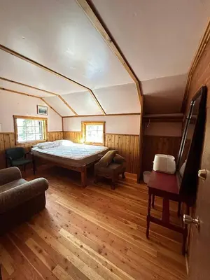 a bedroom with a large bed in a room with wooden floors at Rustic Beaverfoot Lodge Room N10 in Parson