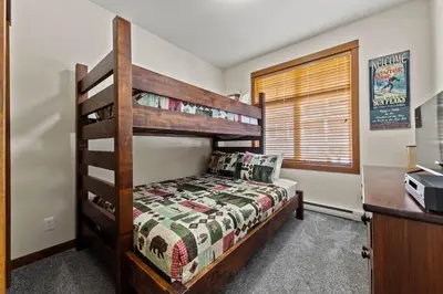 a bedroom with a bunk bed and a desk at Settler's Crossing #56 ski-in ski-out condo with private hot tub in Sun Peaks