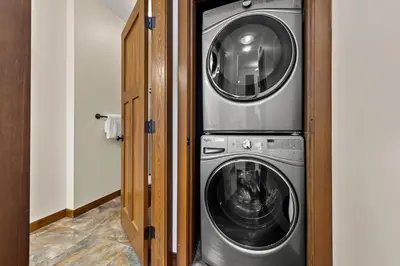 a washing machine and a washer and dryer in a room at Settler's Crossing #56 ski-in ski-out condo with private hot tub in Sun Peaks