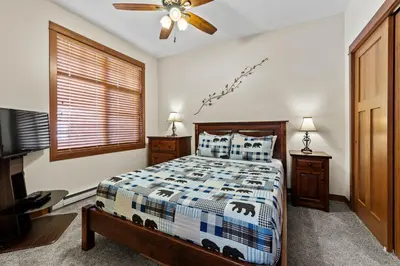 a bedroom with a bed and a ceiling fan at Settler's Crossing #56 ski-in ski-out condo with private hot tub in Sun Peaks