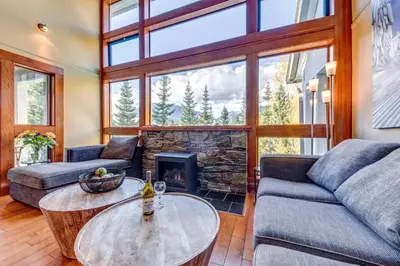 a living room with a couch and a fireplace at Greystone Lodge 320 Ski-in Out in Whistler